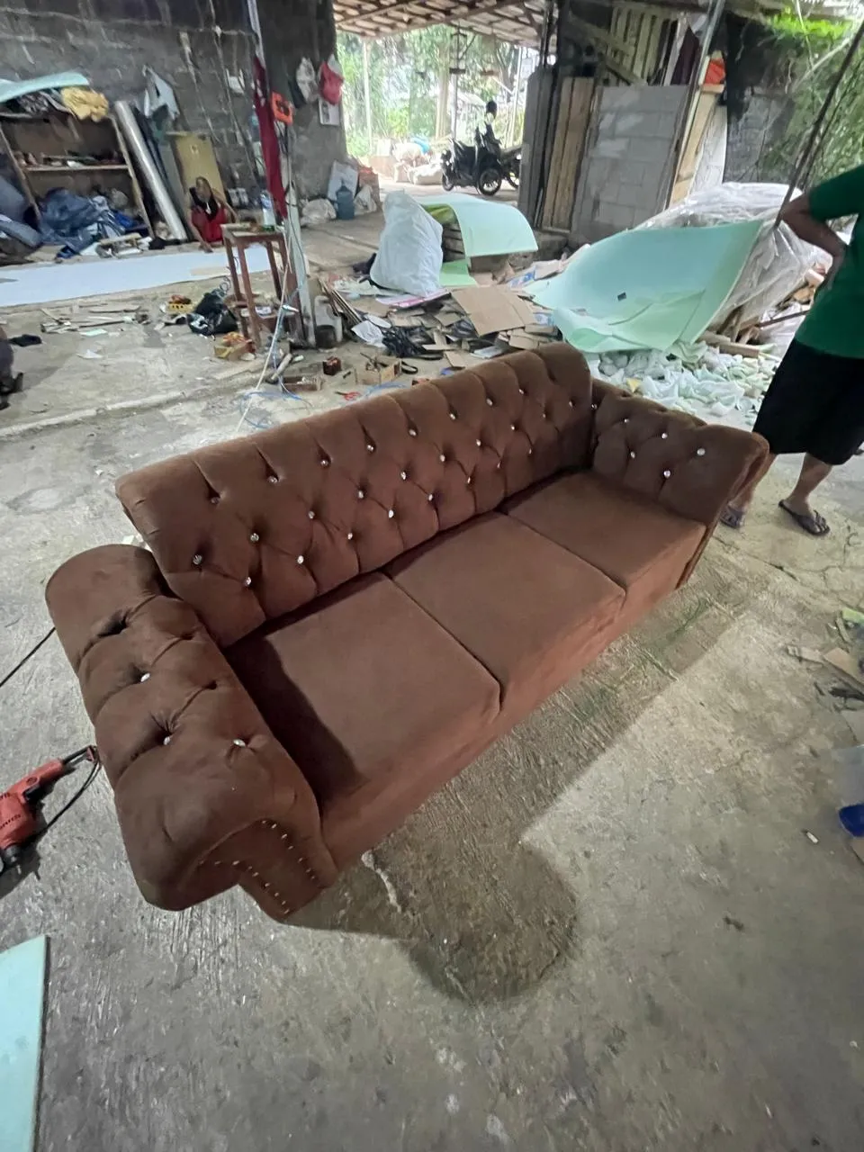 Sofa klasik berkancing cokelat di workshop