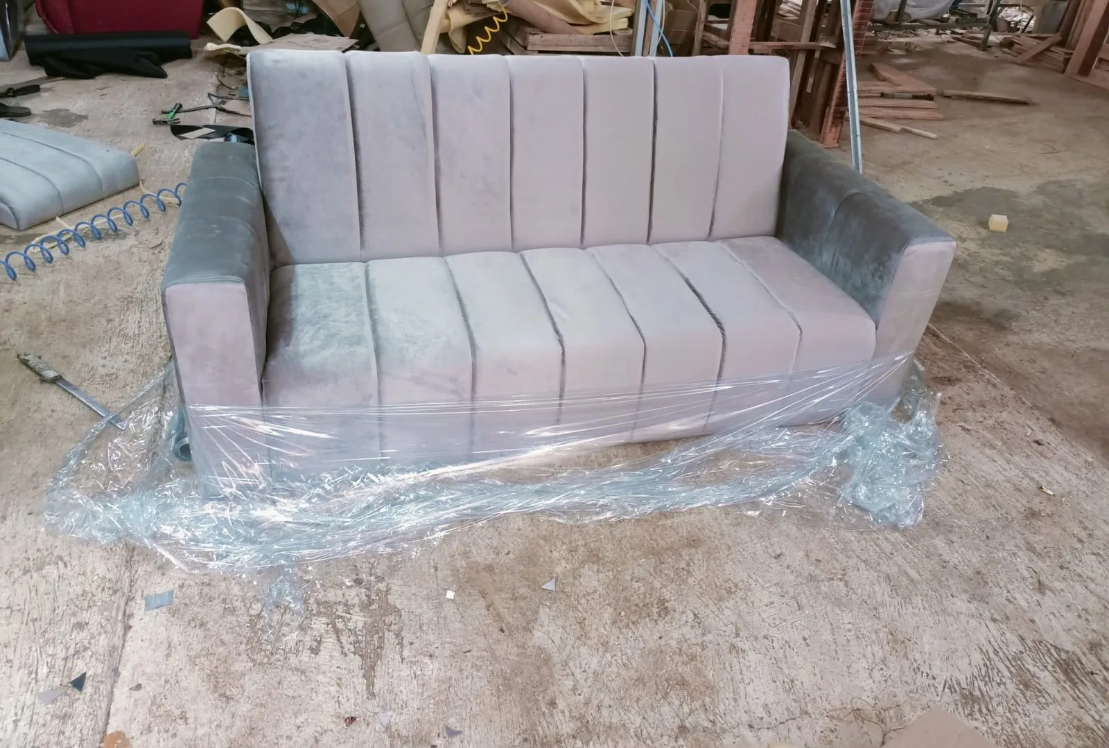 Sofa minimalis dua seater abu-abu yang baru selesai dibuat di workshop