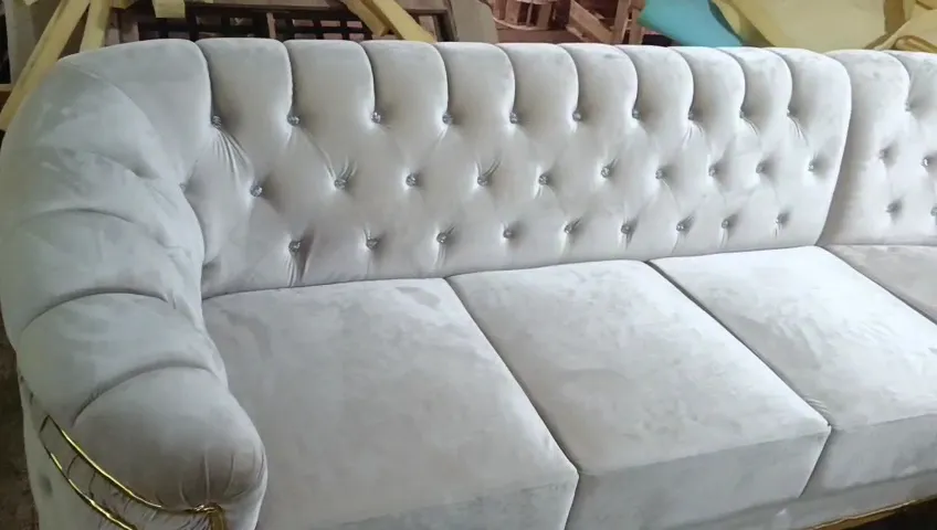 Detail sandaran berkancing pada sofa beludru putih