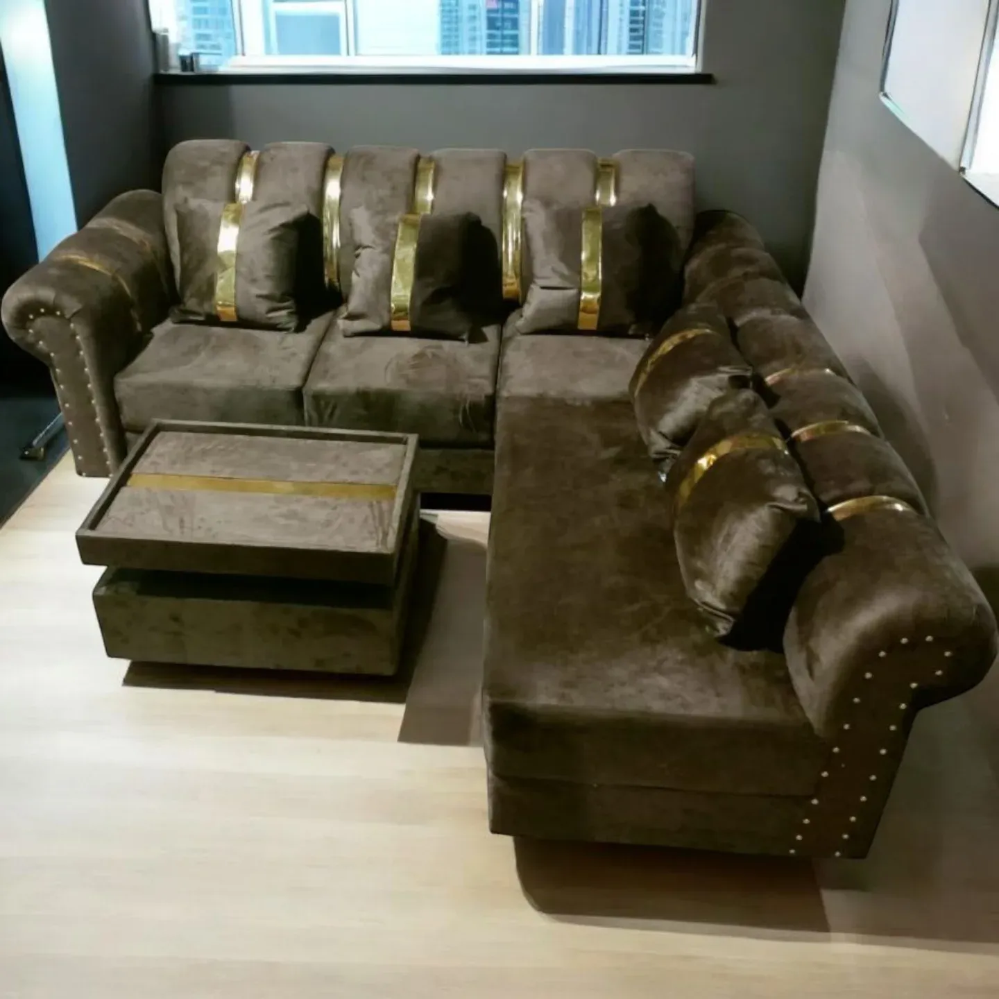Sofa L beludru cokelat dengan lis emas dan meja tamu
